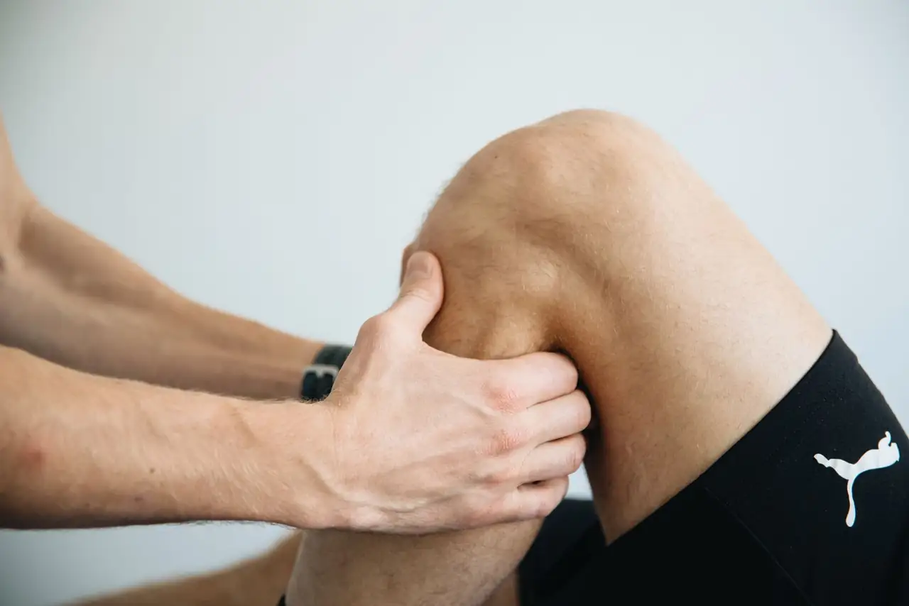 Detailed image of a physiotherapy session focusing on knee massage treatment.